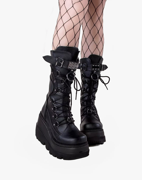 Goth Spike Boots from Street Kawaii shown from the side on model's feet, highlighting intricate stitching and metal accents.