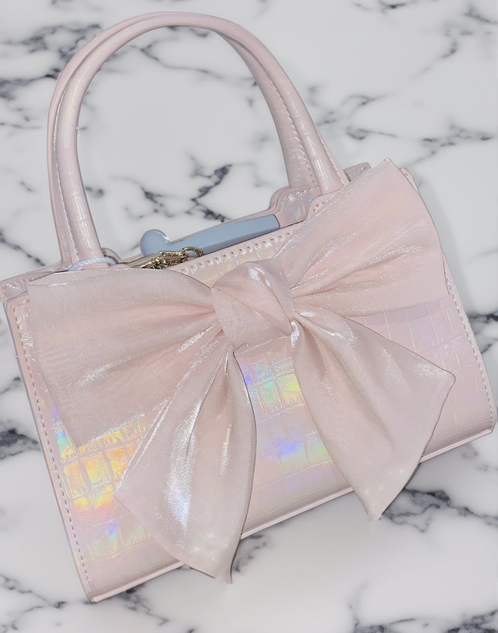 Pink Kawaii Bow Handbag displayed on a marble table, highlighting its durable Microfiber Synthetic Leather.