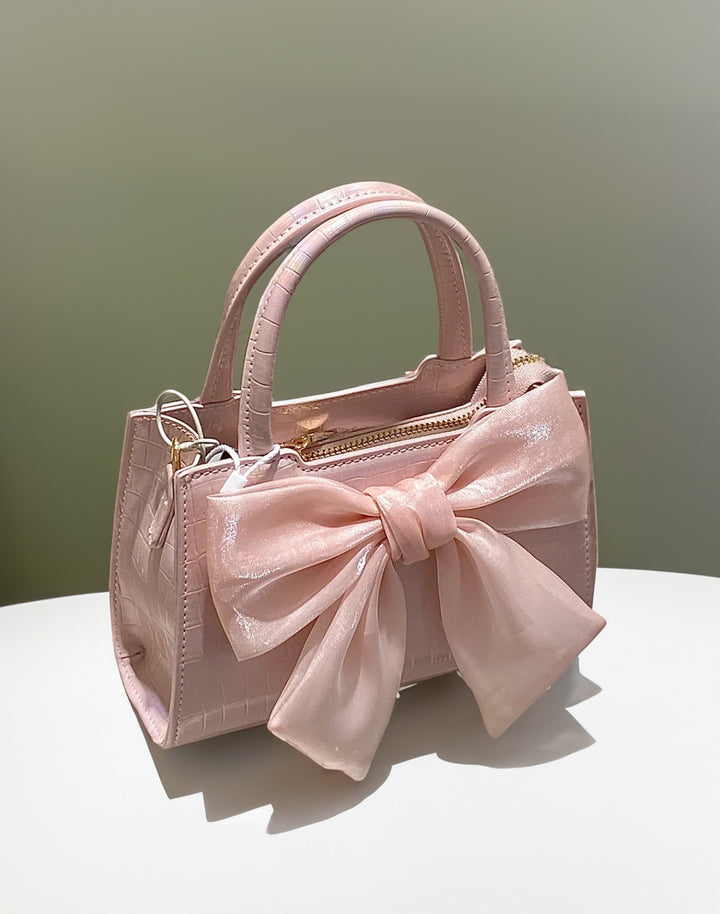 Studio shot of Pink Kawaii Bow Handbag, emphasizing its cute small design.