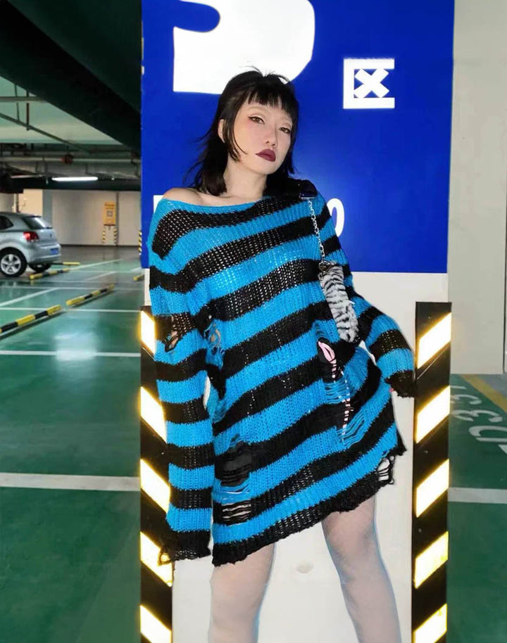 a model in the parking lot wearing frayed blue sweater