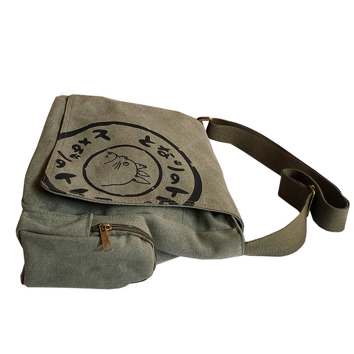 Side view of green Totoro messenger bag with zippered side pocket and adjustable strap.