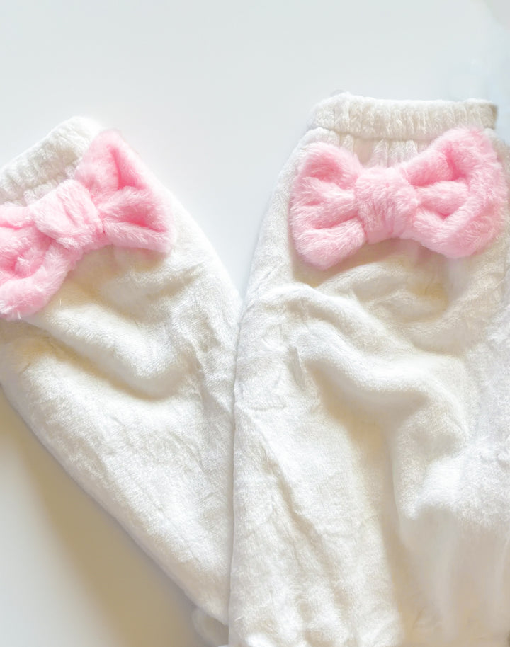 image showing the close up detail of pink bow leg warmers in white color