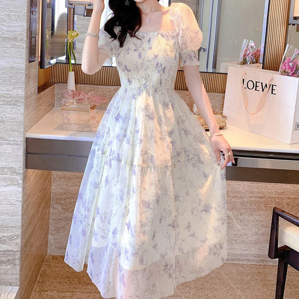 Model wearing Elegant Floral Midi Dress with lavender floral print, square neckline, smocked bodice, and puffed sleeves, perfect for vintage and kawaii fashion.