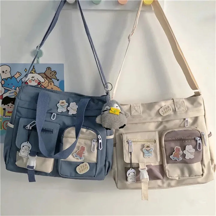 Blue and beige Kawaii Multi-Pocket Nylon Shoulder Bags hanging on hooks, featuring multiple front pockets with cute pins, ideal for casual use and kawaii fashion.
