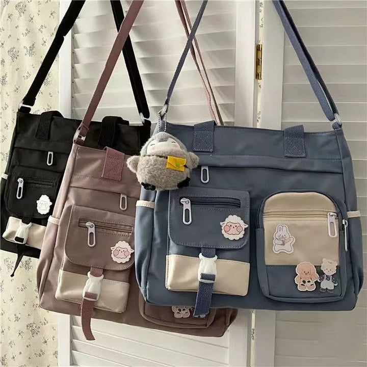 Three Kawaii Multi-Pocket Nylon Shoulder Bags in black, pink, and blue hanging on hooks, showing their stylish design and functional pockets, ideal for kawaii fashion enthusiasts.