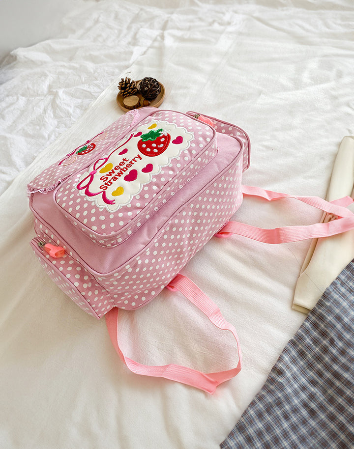 strawberry themed bag on top of the bed