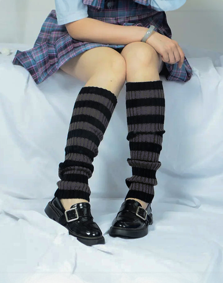 Pair of grey and black striped leg warmers laid out, emphasizing the bold Y2K leg warmers design.